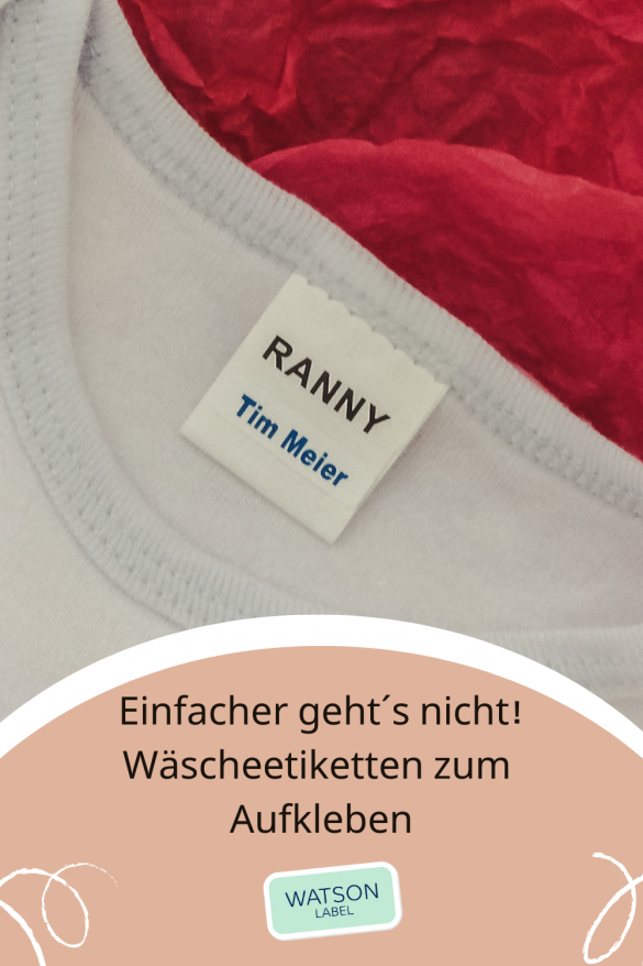 Waescheetiketten-zum-Aufkleben-in-Kleidung-mit-Namen-von. Das kleine weisse Etikett im Format 23 x 6 mm aus weisser Folie mit blauer Schrift klebt auf dem Wäsche Etikett des weißen T-Shirts