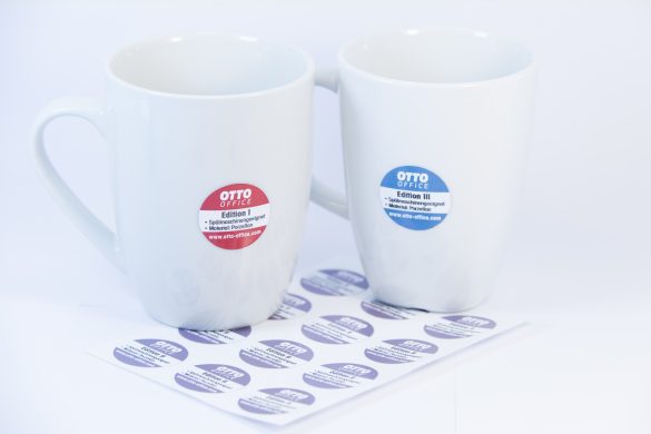 spuelmaschinenfeste-Etiketten mit Logo auf weissen Tassen. Die Logoaufkleber sind 30 mm rund und haften perfekt auf den konischen glaenzenden Tassen.