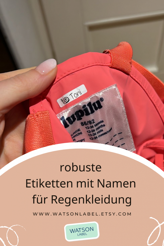 Robuste Namensaufkleber fuer Kindergarten im Format 38 x 6 mm auf roter Lupilu Matschhose fuer Kinder. Die Etiketten sind 23 x 6 mm aus weißer Folie mit schwarzer Schrift und über dem Hosenetikett innen eingeklebt.