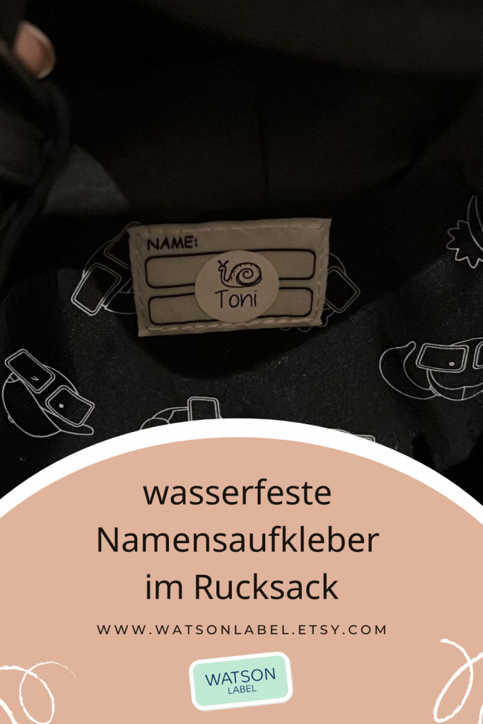 klieiner runder, weißer Namensaufkleber fuer den Kindergarten mit schwarzer Schrift mit Namen  Schnecke Symbol. Der Aufkleber klebt auf dem Namensschild innen im KInder-Rucksack